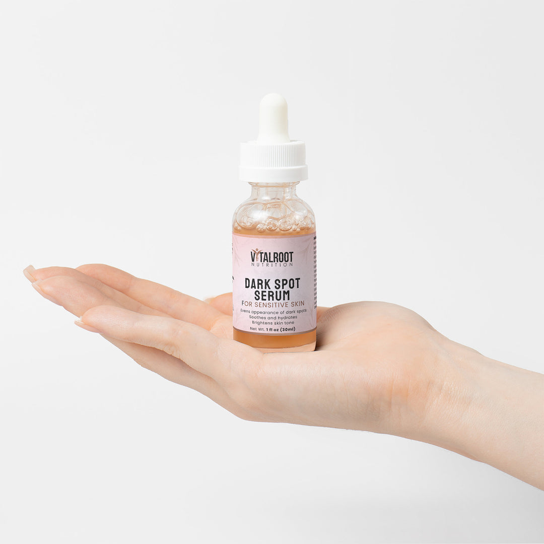 Vitalroot Dark Spot Serum bottle held in a hand on a white background