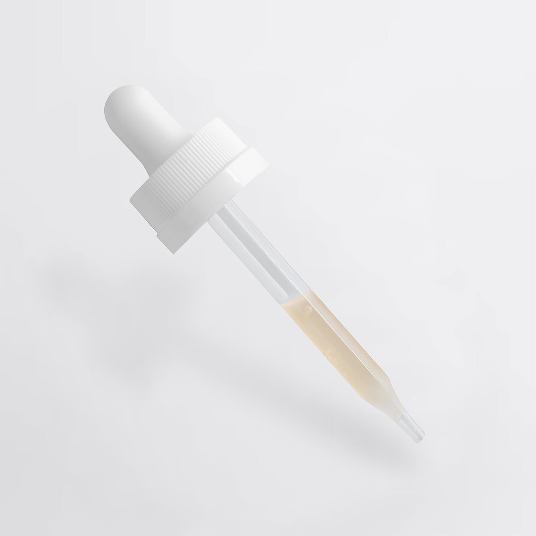 White dropper bottle with a clear liquid on a light gray background