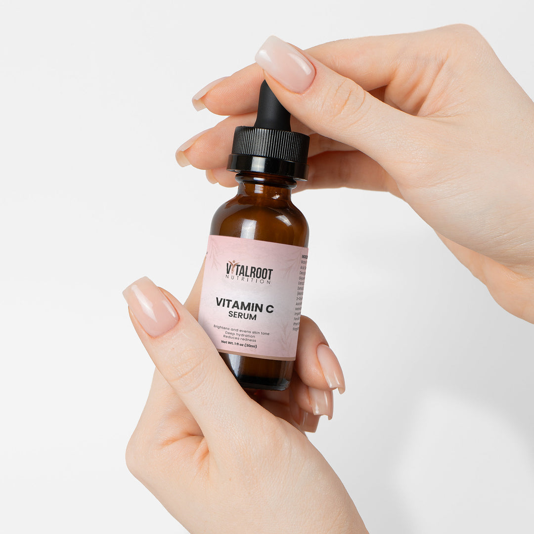 Vitamin C serum bottle held by a hand with a white background