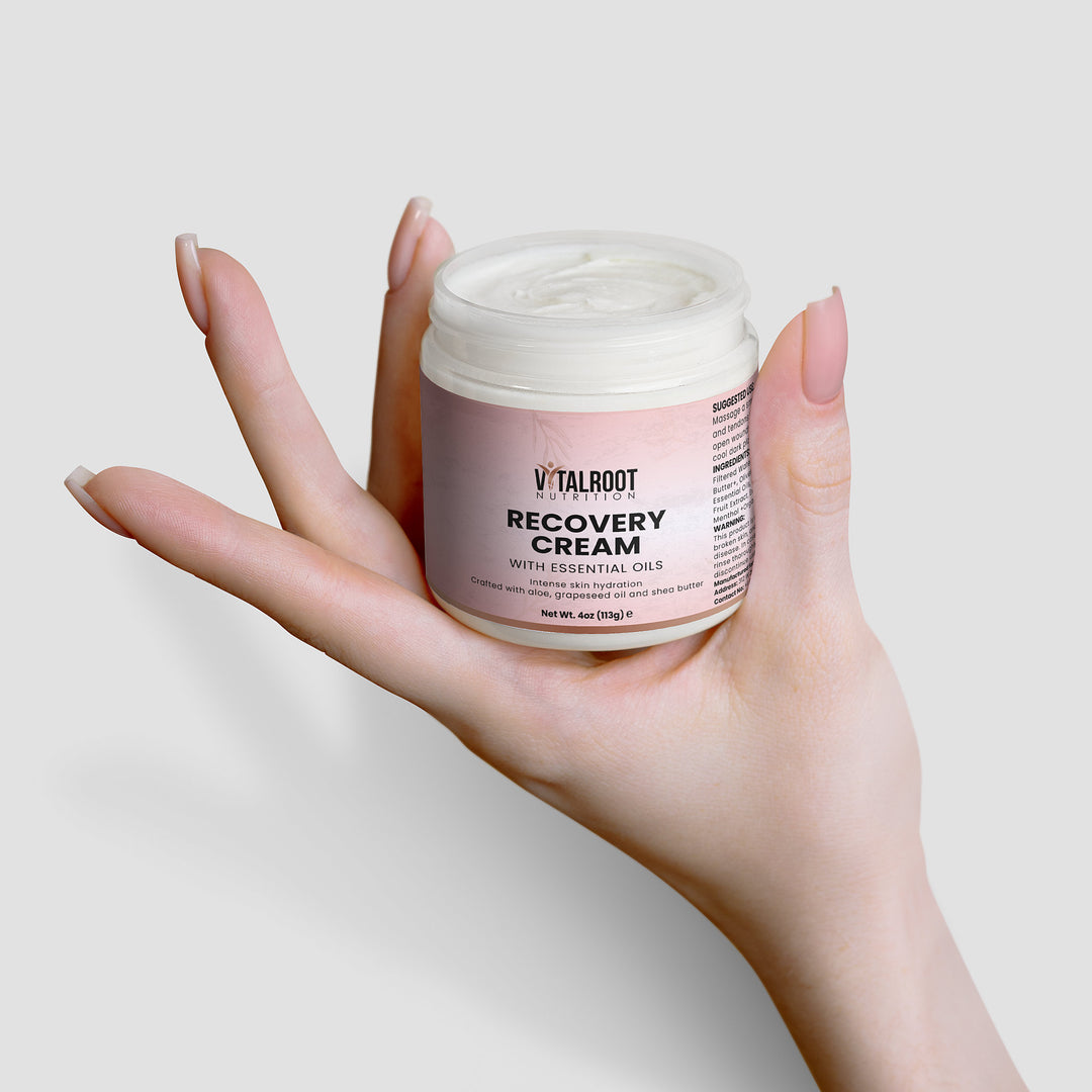 Hand holding a jar of Vitaloot Recovery Cream against a light background