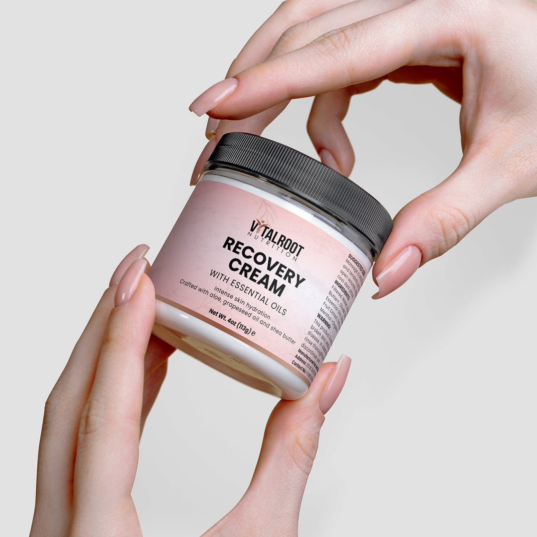 Jar of Vitalroot Recovery Cream held by hands against a neutral background