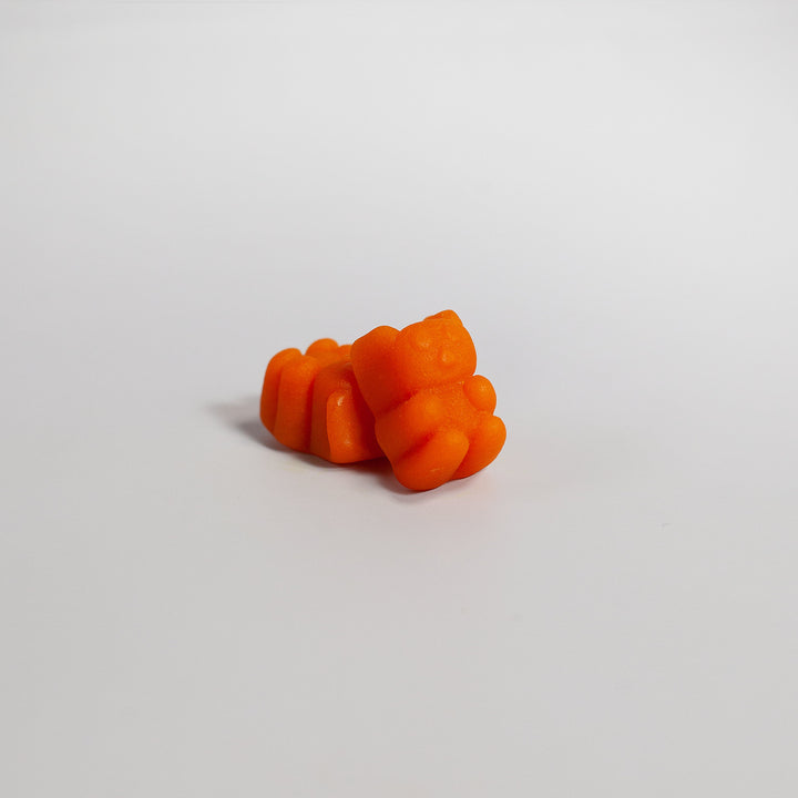 Orange gummy candy on a light gray background