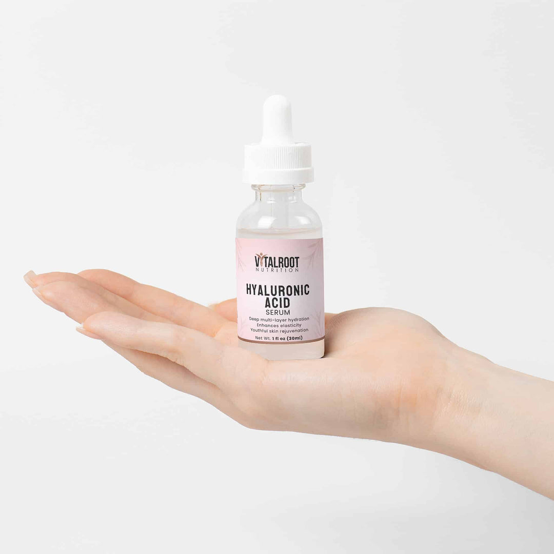 Hand holding a bottle of Vitalroot Hyaluronic Acid Serum against a white background