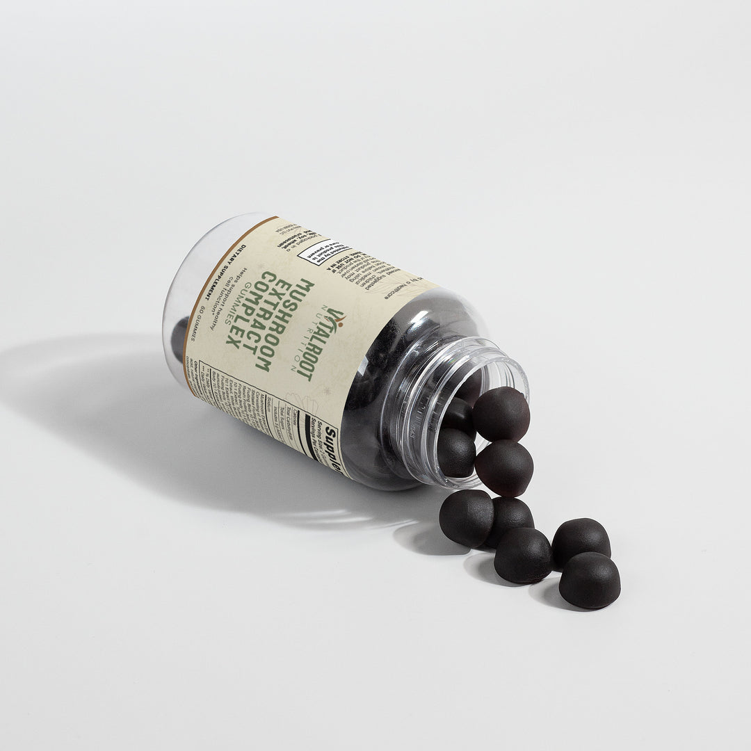 Glass jar with black beads spilling out on a light gray background