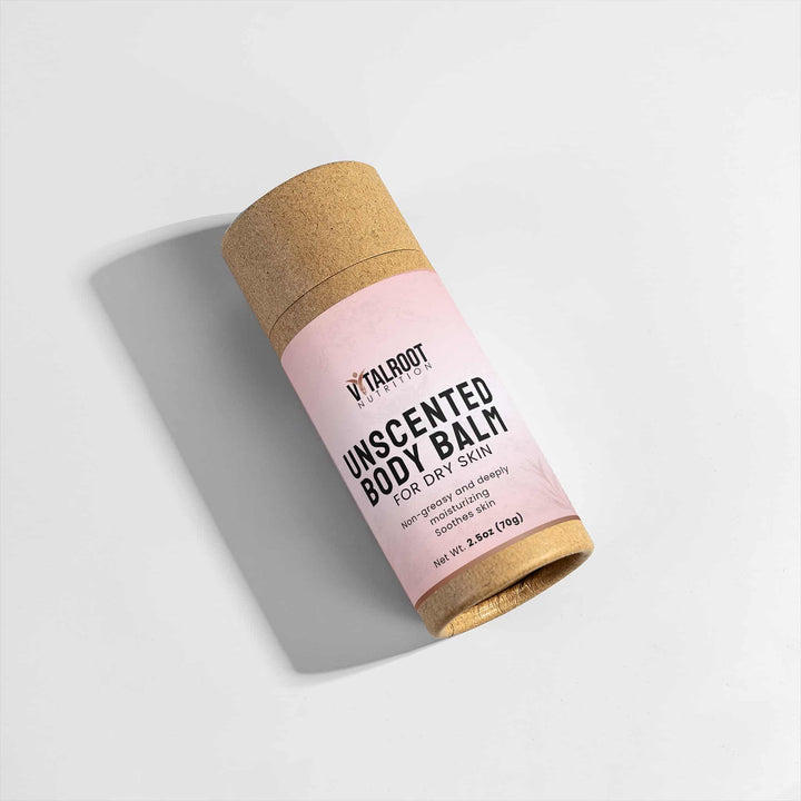 Unscented body balm in a pink container with cork lid on a light gray background