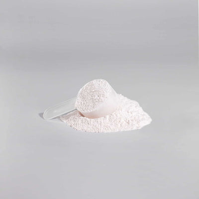 Scoop of Nitric Shock Pre-Workout Powder sitting on top of the powder next to the jar.