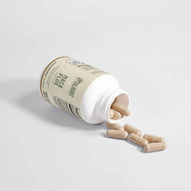 Open Maca Plus bottle by Vital Roots with capsules spilled, used for boosting stamina and vitality